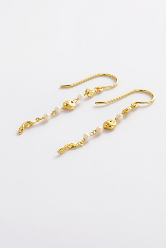 Charlotte Thread Earring - Pearl-Zarla-A delicate thread earring adorned with soft pearls and sculpted accents. Light and fluid in design, it moves effortlessly with you, catching the light with a subtle, sunlit glow. Feminine, refined, and perfect for elevating everyday wear. *18K Gold Plated Solid Brass Base *This piece is handmade and not recommended to be worn in water-Pash + Evolve