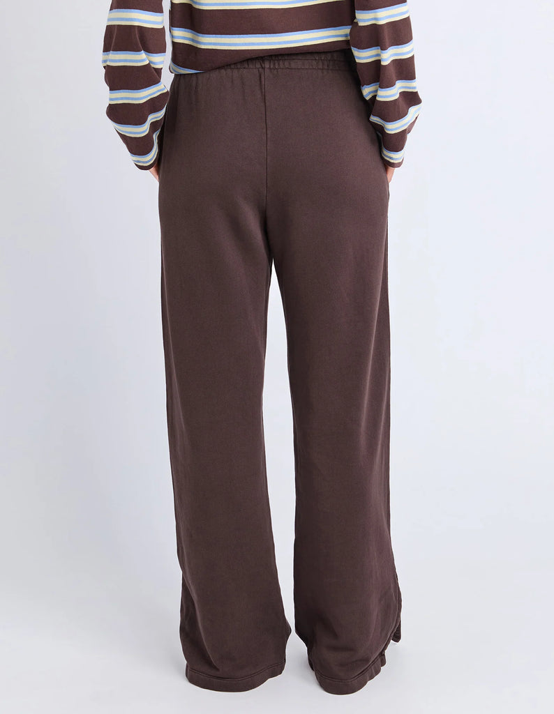 Classic Track Pant - Coffee-Foxwood-Comfort? Tick. Style? Double tick. Our Classic Track Pant is here to level up your lounge game. With an easy elastic waist, playful leg embroidery, and a straight-leg cut that feels as good as it looks—these pants are made for slow mornings and stylish strolls. Bonus points for the hem splits and pockets (because everything's better with pockets). Elastic waist Hem splits Leg embroidery 100% Cotton Our model is 176cm and wears Size 10-Pash + Evolve