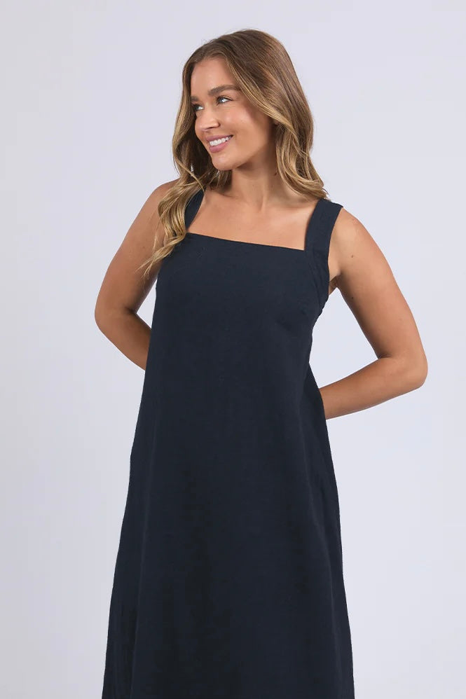 Lourdes dress - navy-Foxwood-Easy going with a playful twist. The Lourdes Dress (Foxwood Clothing) features a relaxed fit with an open back, layered underlay, and a sweet back tie detail that brings the charm. Light, floaty and full of personality—this one’s made for warm days and fun plans. Relaxed fit Wide straps Back tie detail Open back with under layer 55% Linen / 45% Viscose-Pash + Evolve