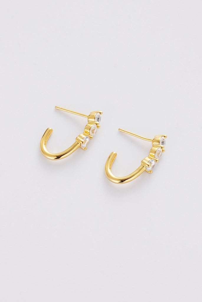 Mara hoop - gold-Pash + Evolve-The Mara Hoop is a refined statement hoop designed to elevate your everyday. Featuring a sleek curved silhouette accented with delicate crystal detailing, these gold hoop earrings add just the right amount of shine and polish to any look. Lightweight yet impactful, they’re perfect for day-to-night styling - wear them solo for a clean finish or pair with simple studs for a layered ear look. Metal: 18K Gold Plated on Brass baseDimensions: 20mm outer diameter, 13mm inner diamete
