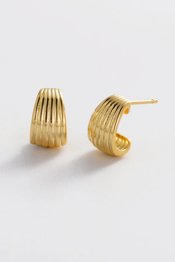 Sasha Hoop Small - Gold-Zafino-The Sasha Small Earrings feature a sculptural ribbed design with a smooth, polished gold finish. Their compact silhouette adds subtle texture and dimension, making them the perfect everyday statement piece. Bold yet refined, Sasha Small brings a modern touch to any jewellery look while remaining versatile enough for both casual styling and elevated occasions. Metal: 18K gold plated on brass base Dimensions: 6.7mm width + 11mm length Water Resistant: Handle occasional water ex
