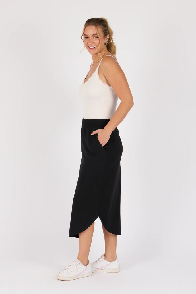 Scoop hem midi skirt - black-One Ten Willow-Shirred Elastic Waistband Scoop Hem Midi Length Side Seam Pockets Designed in Geelong Material: 95% Cotton 5% Elastane Model is 176cm (Size 8-10) and wears our size Small-Pash + Evolve