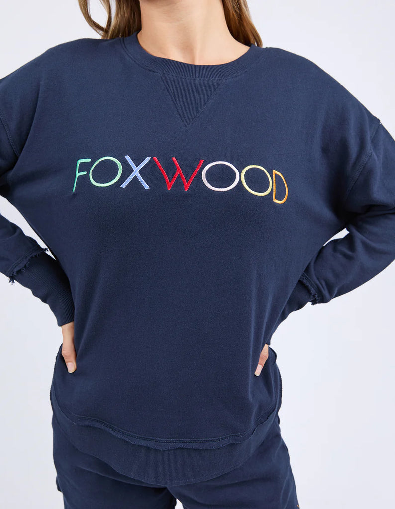 Simplified Confetti Crew - Navy-Foxwood-Say hello to your new feel-good fave. The Simplified Confetti Crew brings all the comfort with a playful twist. With multicoloured embroidery on the chest, raw edge details, and a curved hem that flatters every fit, it's the kind of piece you'll want to wear on repeat. Easy to throw on, even easier to love. One colour just won’t be enough. Front chest multicoloured embroidery Raw edge detail Curved hem 100% Cotton Model is wearing a size 10-Pash + Evolve