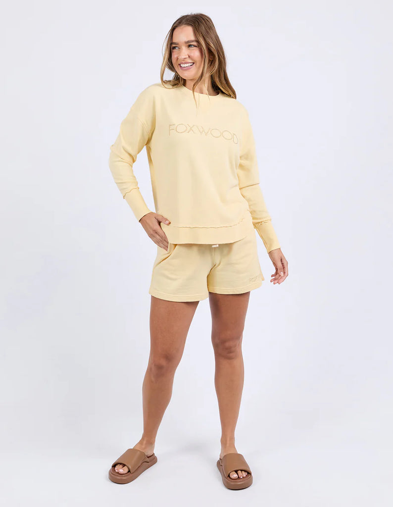 Simplified Crew - Lemon-Foxwood-The Simplified Crew is the perfect throw over for your everyday wardrobe. With its round neck, hi-lo hemline, side splits with raw edging & the classic Foxwood logo, you are going to want one in every colour. Front chest embroidery Raw edge detail Curved hem 100% Cotton Model is wearing a size 10-Pash + Evolve