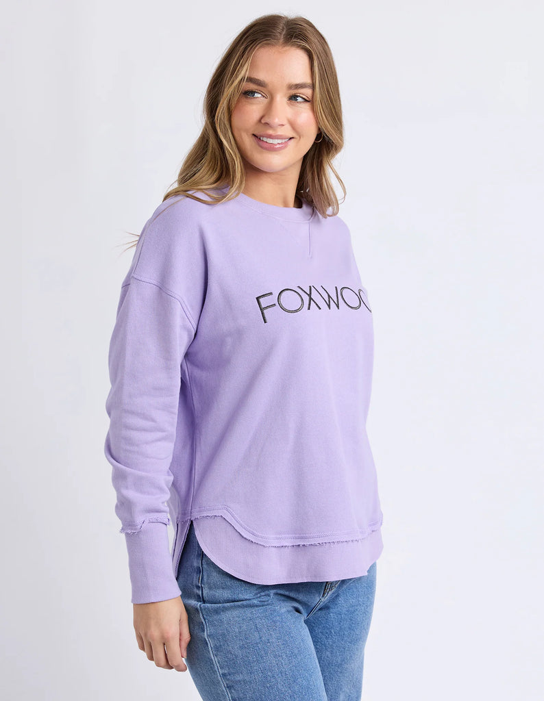 Simplified Metallic Crew - Lavender-Foxwood-The Bling version of our Best Selling Simplified Crew. This crew is the perfect throw over for your everyday wardrobe. With its round neck, hi-lo hemline, side splits with raw edging & the classic Foxwood logo, you are going to want one in every colour. The Metallic Crew has a stunning lurex thread run through the Foxwood embroidery for that little bit 'extra'. Front chest embroidery Raw edge detail Curved hem 100% Cotton Our model is 176cm and wears Size 10-Pash