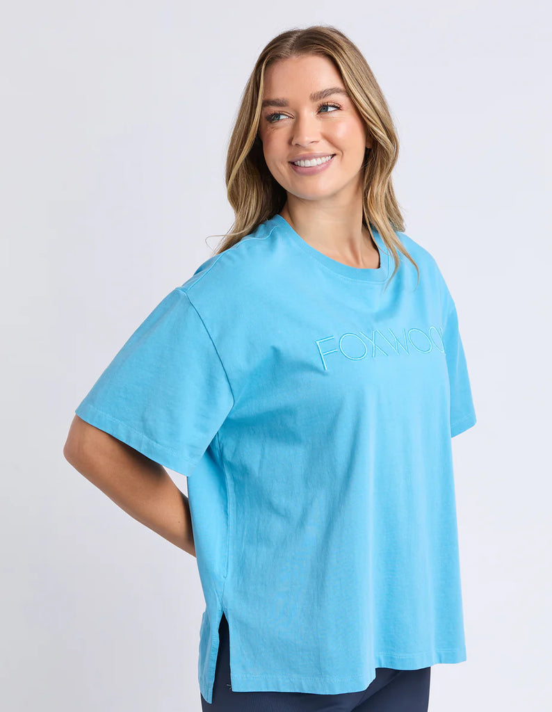 Simplified Tee - Sky-Foxwood-The Simplified Tee is the perfect throw over for your everyday wardrobe. With its round neck, hi-lo hemline, side splits with raw edging & the classic Foxwood logo, you are going to want one in every colour. Front chest embroidery Round neckline Relaxed fit 100% Cotton Our model is 176cm and wears Size 10-Pash + Evolve
