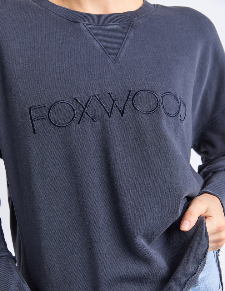 Washed Simplified Crew - Navy-Foxwood-The Washed version of our Best Selling Simplified Crew. This crew is the perfect throw over for your everyday wardrobe. With its round neck, hi-lo hemline, side splits with raw edging & the classic Foxwood logo, you are going to want one in every colour. The Washed version has a vintage look for that much-loved look from the get-go. Front chest embroidery Raw edge detail Curved hem 100% Cotton Model is wearing a Size 10-Pash + Evolve