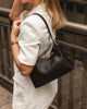 Amelia shoulder bag - black-Louenhide-The Amelia Black Shoulder Bag is a striking addition to your collection of minimalist handbags, defined by clean lines and a distinctive, asymmetrical structured silhouette. With elevated detailing and a modern edge, Amelia offers a fresh perspective on everyday styling. Finished in smooth chocolate vegan leather and accented with refined gold hardware, she brings instant polish to any look. Internal Features Zip Pocket, Slip Pocket Internal Lining Polyester Recycled B