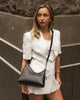 Amelia shoulder bag - black-Louenhide-The Amelia Black Shoulder Bag is a striking addition to your collection of minimalist handbags, defined by clean lines and a distinctive, asymmetrical structured silhouette. With elevated detailing and a modern edge, Amelia offers a fresh perspective on everyday styling. Finished in smooth chocolate vegan leather and accented with refined gold hardware, she brings instant polish to any look. Internal Features Zip Pocket, Slip Pocket Internal Lining Polyester Recycled B