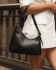 Amelia shoulder bag - black-Louenhide-The Amelia Black Shoulder Bag is a striking addition to your collection of minimalist handbags, defined by clean lines and a distinctive, asymmetrical structured silhouette. With elevated detailing and a modern edge, Amelia offers a fresh perspective on everyday styling. Finished in smooth chocolate vegan leather and accented with refined gold hardware, she brings instant polish to any look. Internal Features Zip Pocket, Slip Pocket Internal Lining Polyester Recycled B