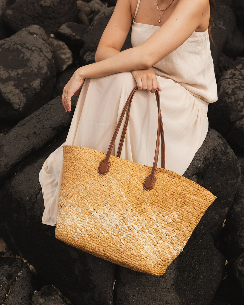 Ava Basket Tote - Natural Raffia-Louenhide-The Ava Natural Raffia Basket Tote is your effortlessly stylish plus-one for sun-drenched days and spontaneous summer moments. Crafted from natural raffia in a structured open-top basket silhouette, she blends relaxed elegance with warm-weather practicality - perfect for everything from seaside escapes to spritz-soaked afternoons in the sun. Her slim, elongated handles in smooth tan vegan leather add a refined contrast and comfortable carry, whether worn over the s