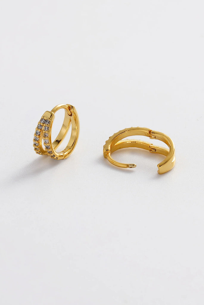 Celia Huggie - Gold-Zafino-The Celia Huggie features a sleek double-row crystal design set into a polished gold hoop, creating a refined sparkle with a modern edge. Designed to sit close to the ear, this elegant huggie offers just the right amount of shine for both everyday wear and elevated occasions. Chic and versatile, Celia is perfect worn alone or layered with other earrings for a curated ear look. Metal: 18K gold plated on brass base Dimensions: 12mm outer diameter, 9.35mm inner diameter + 5.4mm width