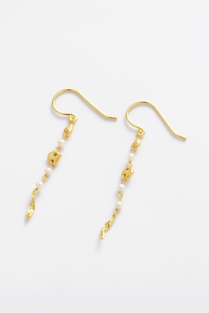 Charlotte Thread Earring - Pearl-Zarla-A delicate thread earring adorned with soft pearls and sculpted accents. Light and fluid in design, it moves effortlessly with you, catching the light with a subtle, sunlit glow. Feminine, refined, and perfect for elevating everyday wear. *18K Gold Plated Solid Brass Base *This piece is handmade and not recommended to be worn in water-Pash + Evolve