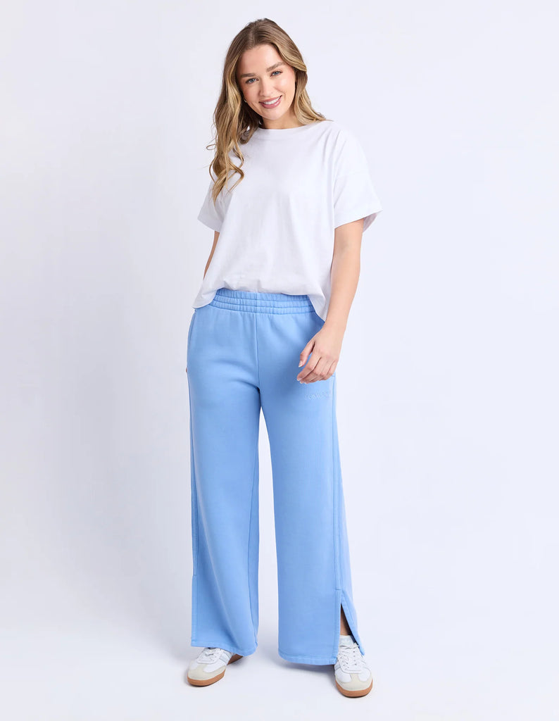 Classic Track Pant - Blue-Foxwood-Comfort? Tick. Style? Double tick. Our Classic Track Pant is here to level up your lounge game. With an easy elastic waist, playful leg embroidery, and a straight-leg cut that feels as good as it looks—these pants are made for slow mornings and stylish strolls. Bonus points for the hem splits and pockets (because everything's better with pockets). Elastic waist Hem splits Leg embroidery 100% Cotton Our model is 176cm and wears Size 10-Pash + Evolve