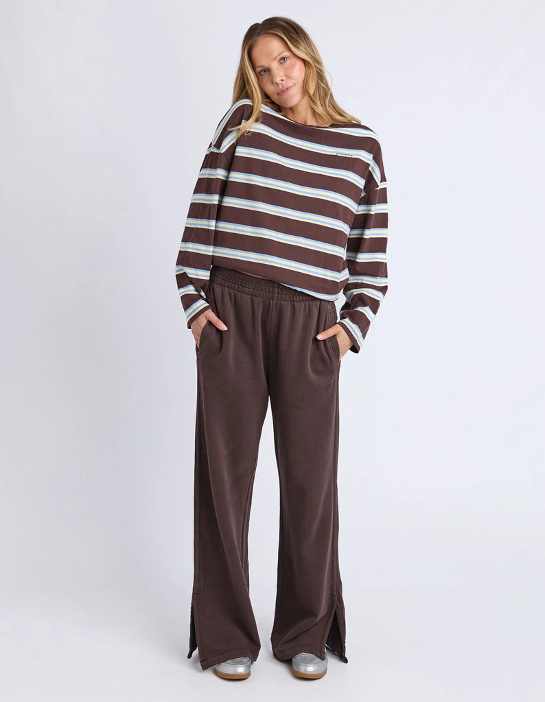 Classic Track Pant - Coffee-Foxwood-Comfort? Tick. Style? Double tick. Our Classic Track Pant is here to level up your lounge game. With an easy elastic waist, playful leg embroidery, and a straight-leg cut that feels as good as it looks—these pants are made for slow mornings and stylish strolls. Bonus points for the hem splits and pockets (because everything's better with pockets). Elastic waist Hem splits Leg embroidery 100% Cotton Our model is 176cm and wears Size 10-Pash + Evolve