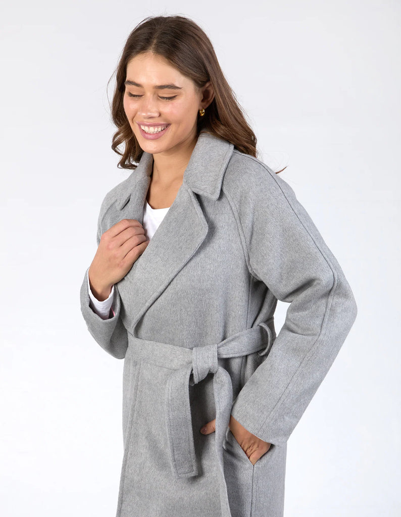 Farrah coat - grey marle-Elm-A coat for the ages. This gorgeous wool melton blend coat features a endlessly flattering long line shape with button openings and lapel collar. The jacket has pockets and is not lined making it versatile for all weather. Long line shape Button opening with pockets No lining 90% Polyester, 10% Wool Model is wearing a size 10-Pash + Evolve