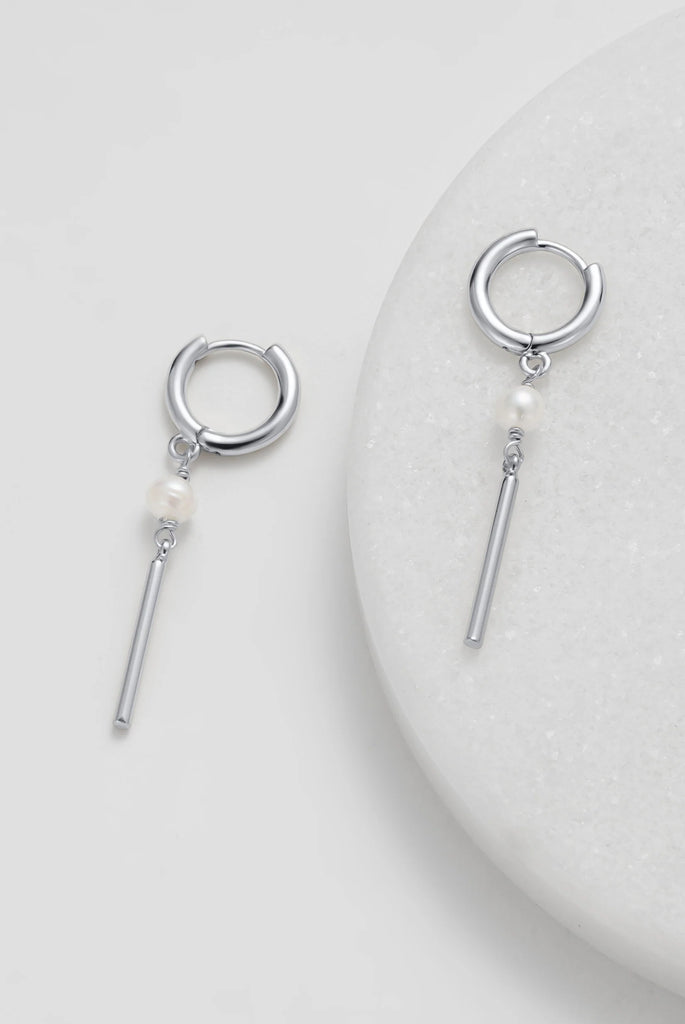 Isabelle Earring - Silver-Zafino-The Isabelle Earring is a refined blend of modern minimalism and timeless elegance. Featuring a classic gold huggie adorned with a delicate freshwater pearl and a sleek bar drop, this design moves effortlessly with you—adding a touch of sophistication to both everyday wear and evening looks. Metal: 18K Gold Plated on BrassDimensions: 8mm Hoop, 40mm DropWater Resistant: Splash proof, not recommended to be worn in the ocean or pool Freshwater Pearl Water resistant Hypoallergen