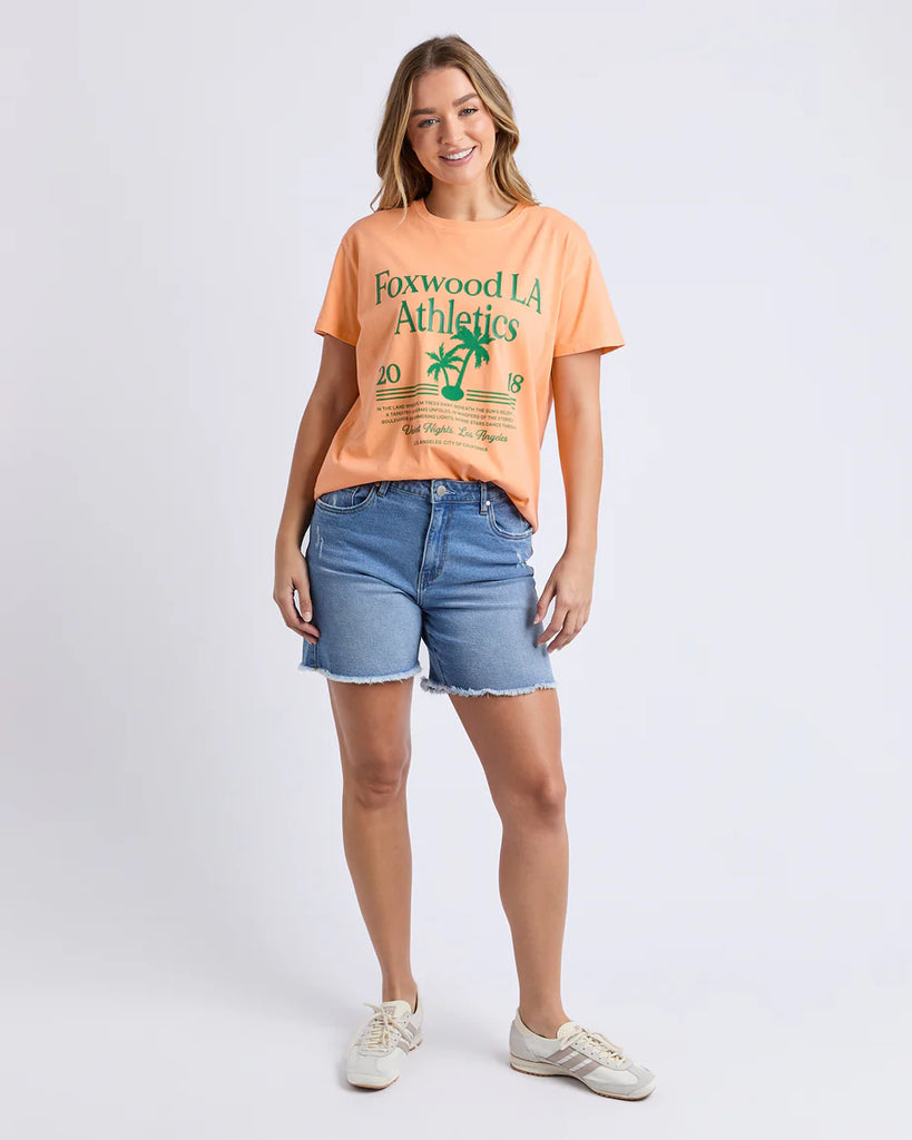 La Aths Tee - Peach-Foxwood-The LA Aths Tee brings a fun, sporty edge to your casual look. Made from soft 100% cotton, it features an exclusive Foxwood front chest print with bold lettering and a palm graphic. Designed with a round neckline and relaxed fit, it’s an easy style for everyday wear. Foxwood exclusive front chest print Round neckline Relaxed fit 100% Cotton Model is wearing a size 10-Pash + Evolve