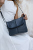 Lexci bag - Navy Blue-Baleka Leather-Defined by minimalistic elegance, the Lexci bag features a sleek foldover silhouette with thoughtful details. A secure zip closure, discreet back zip pocket and two sophisticated compartments - including a front section with an internal zip and pockets for seamless organisation. Fully lined and designed for versatility, the adjustable strap lets you wear it crossbody or over the shoulder with effortless ease - Lexci is your everyday essential! A versatile and minimalist