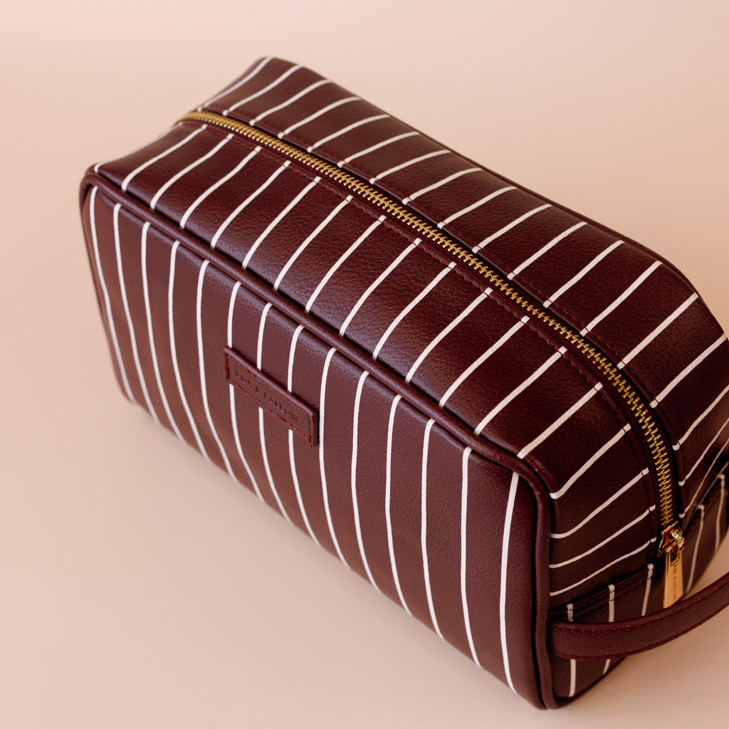 Merlot Pinstripe Wash Bag-Fox & Fallow-The bag of your dreams is here! With so many bonus features, you’ll be wondering where they’ve been all your life. Beautiful, but practical. Perfect as an everyday make up bag or for all your bathroom essentials for the next work trip or vacay. Crafted from super soft, yet durable luxury pebble vegan leather it's easy to keep clean - simply wipe down with a damp cloth. The monogrammed tan lining is designed to hide make up or spills but also makes it easy to find all 