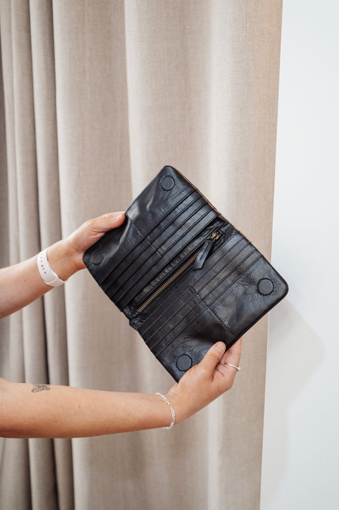 Noa wallet - black-Baleka Leather-Sleek, functional, and effortlessly modern — the Noa Wallet is designed to keep your essentials beautifully organized. It features a magnetic closure for a smooth, secure snap and a back zip pocket for quick-access items. Inside, you’ll find a thoughtfully designed layout with an internal zip compartment, 2 note dividers, and 16 card slots The Noa Wallet combines practicality with a minimalist aesthetic, making it the perfect accessory for wherever your day takes you. Magne