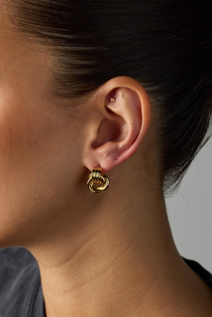 Poppy earring - gold-Zafino-Introducing the Poppy Earrings – chic studs with a mesmerising braided design. Combining timeless elegance and contemporary style, these lightweight earrings elevate any look. The intricately braided pattern adds sophistication to your ensemble, making the Poppy Earrings your go-to for understated charm on any occasion. 18K Gold Plated Solid Brass Base 14mm (w) x 17mm (L) Splash Proof: Splashes or occasional water contact-Pash + Evolve
