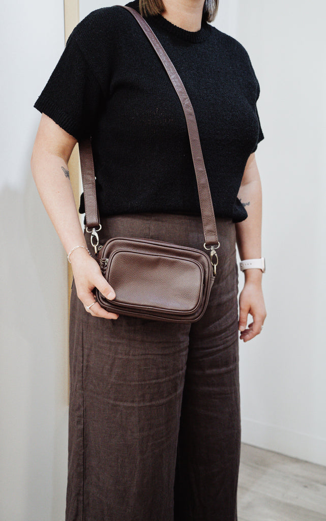 Remi crossbody bag - Chocolate Pebble-Baleka Leather-Chic, compact & endlessly versatile. The Remi is our most versatile and practical bag - thoughtfully designed to keep up with your day. Featuring a front compartment for your must-have essentials, a sleek back pocket with secure press stud closure and a spacious main compartment complete with an internal zip pocket and slip pocket for a neat interior layout. Fully lined and finished with an adjustable strap that can be worn on the shoulder or crossbody, R