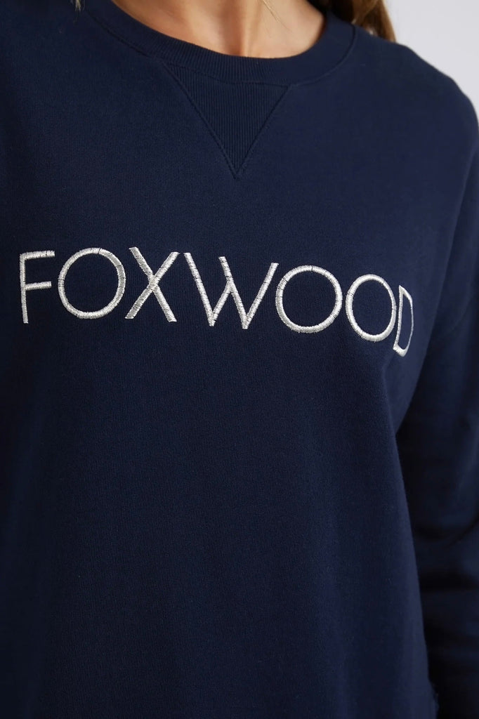 Simplified Metallic Crew - Navy-Foxwood-Say hello to our bling version! If you can't help yourself when it comes to a touch of glitz, then the Metallic Simplified Crew is the perfect addition to your everyday wardrobe. Its round neck, hi-lo hemline, side splits with raw edging and classic Foxwood logo will make you want one in every colour. Everyone loves this best selling crew from Foxwood Clothing. Round crew neckline Classic Foxwood chest logo in lurex metallic thread Side splits Raw edging on cuffs and 