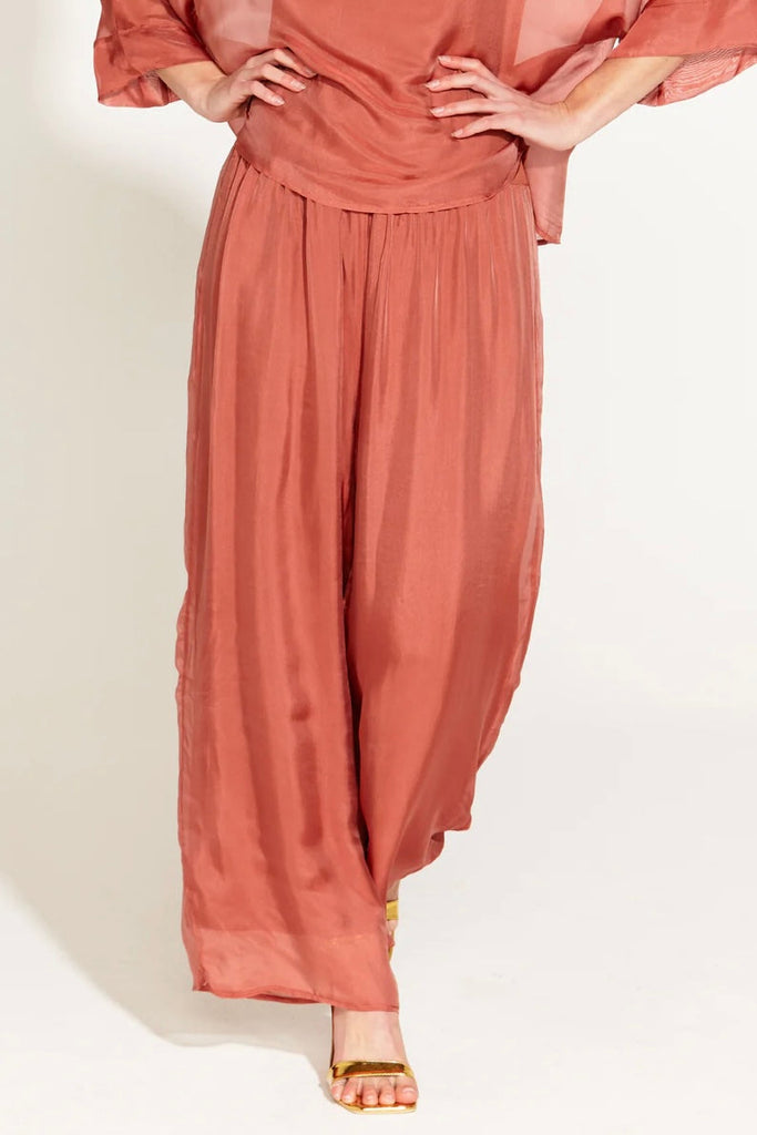 Sunlight And Shadow High-Waisted Silk Wide Leg Pant - Burnt Rose-FATE + BECKER-Drape yourself in opulence with our Sunshine and Shadow Silk Pant � a masterpiece in relaxed sophistication. The wide-leg silhouette exudes timeless elegance, while the jersey waistband ensures luxurious comfort. Elevate your style effortlessly with these silk pants, where comfort meets couture in perfect harmony. Shine bright in the Sunshine and Shadow collection a celebration of refined fashion. -Relaxed Fit -Wide Leg -Jersey C