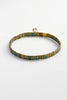 Tile bracelet -olive-Zafino-This minimalist bracelet is crafted from flat, rectangular beads in a deep iridescent olive. The dark, shimmering tones are balanced by slender gold-tone vertical spacers for a refined and modern finish. *18K Gold Plated Solid Stainless Steel Base *17cm Elastic *Water proof: Can be worn in the ocean or pool-Pash + Evolve