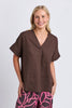 Wander top - coffee-Elm-Easy to wear and beautifully flattering, the Wander Top is designed with a soft V-neckline, centre front pleat and gently curved hem for effortless everyday style. Crafted from a breathable linen blend, it drapes beautifully and pairs perfectly with denim, relaxed linen pants or the matching Wander Pant. V neckline Pleat at centre front Curved hemline Relaxed fit 55% linen 45% viscose The Model is 173cm and is wearing a size 10-Pash + Evolve